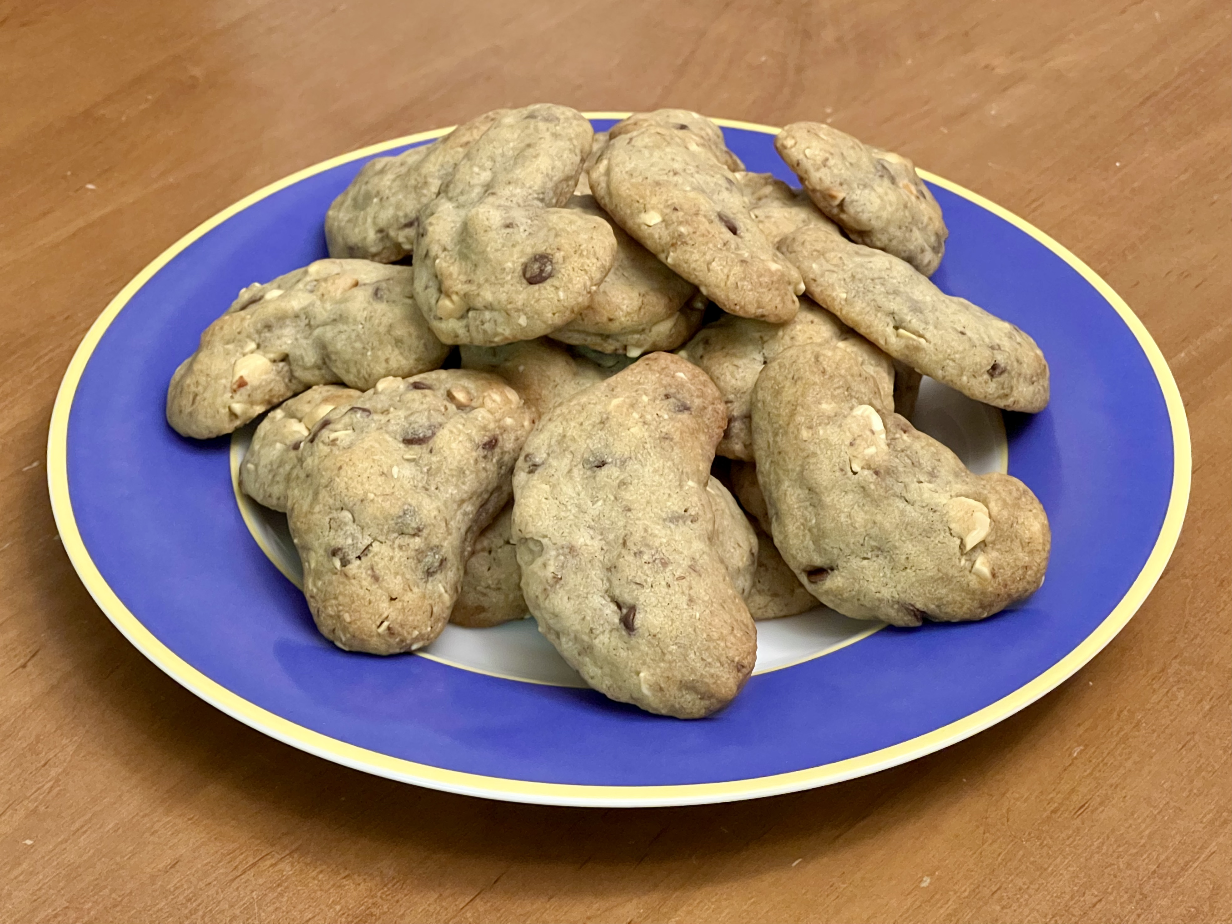 A plate piled with cookies shaped roughly like bananas.