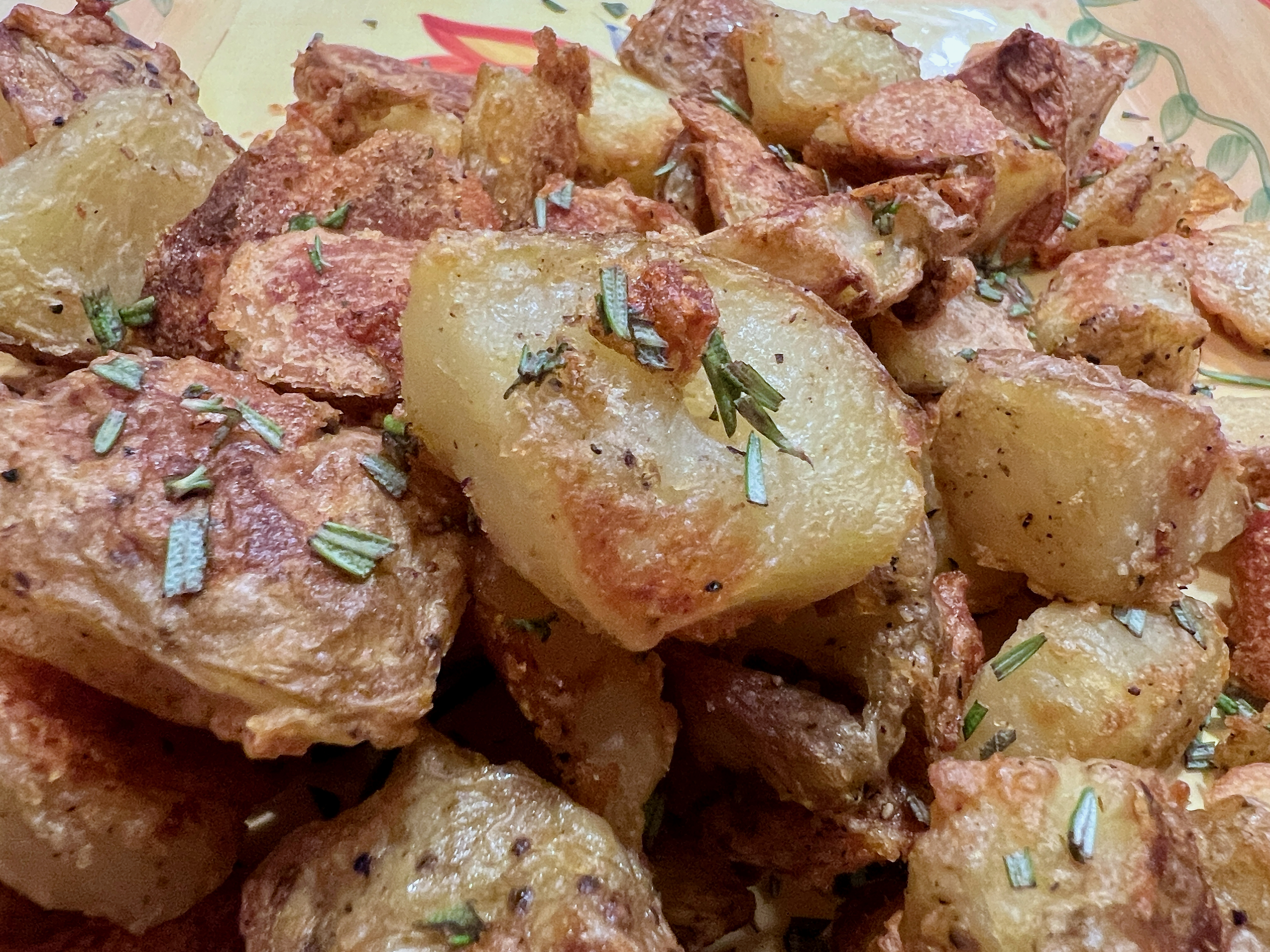 Golden-brown skin-on potato pieces, with crispy and craggily edges.